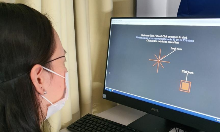 Volunteer at home computer demonstrating visual field test software