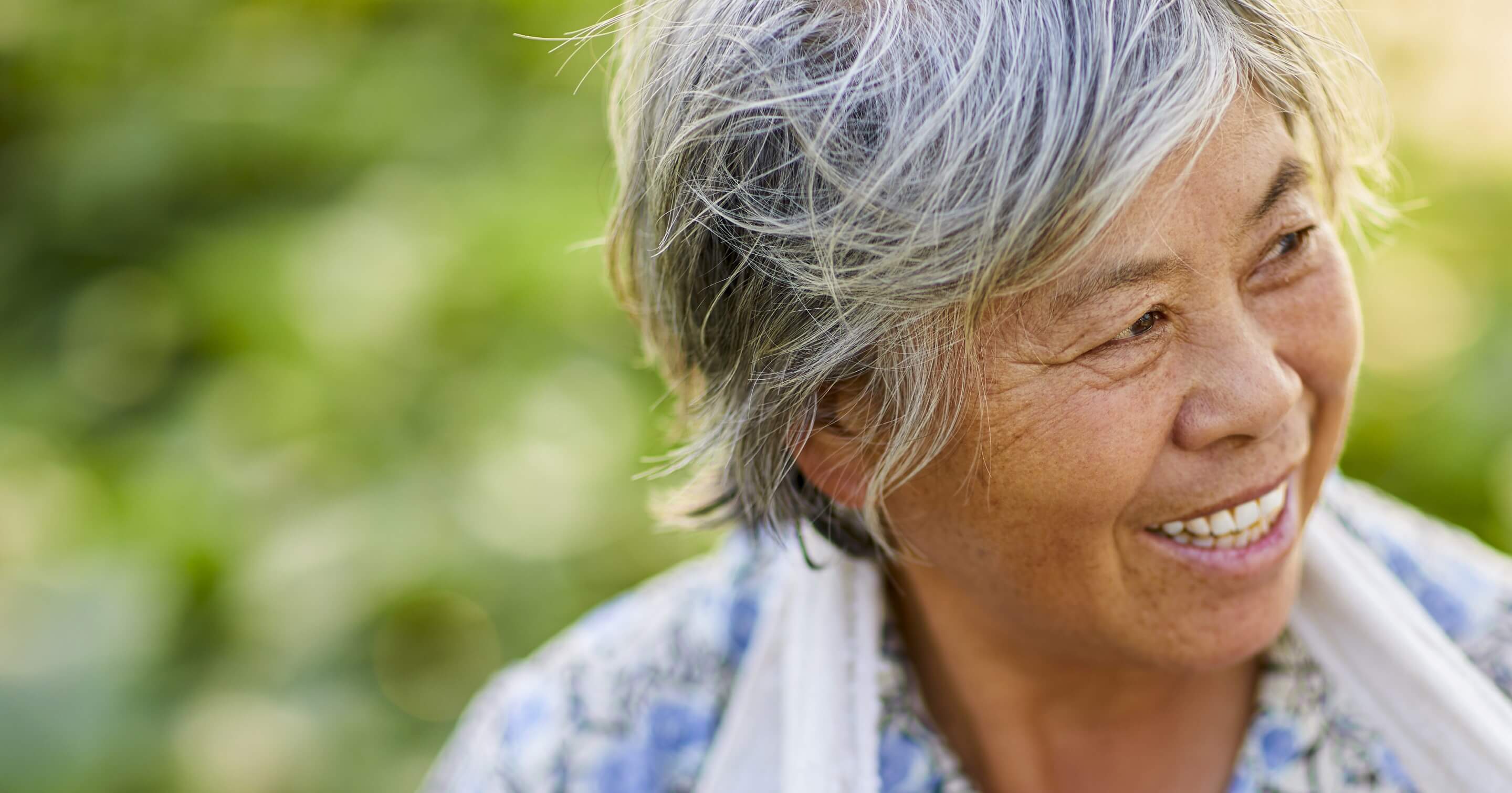 Happy, natural looking Asian woman smiling to her left