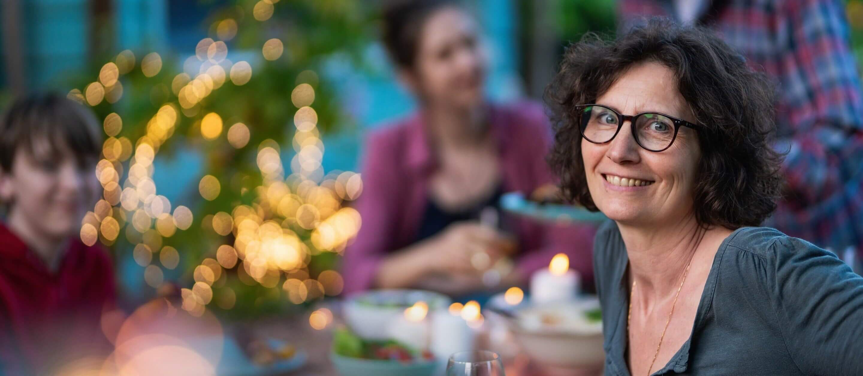 Woman eating outside at night with her family 