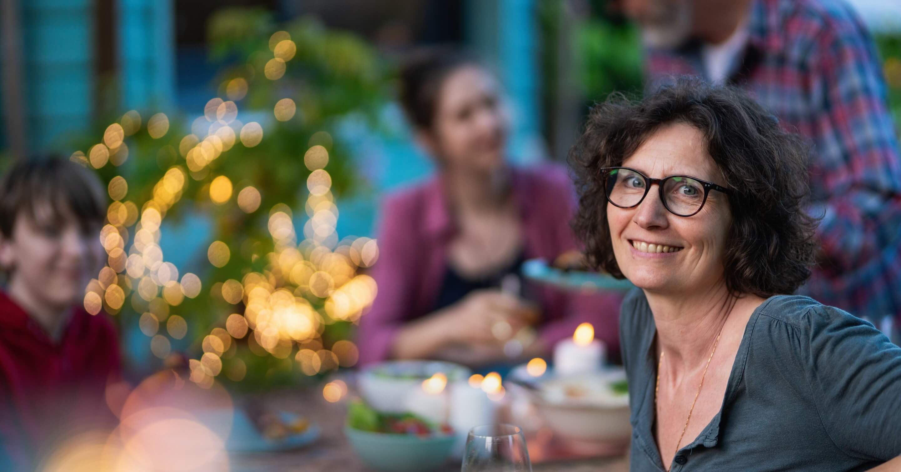 Woman eating outside at night with her family 
