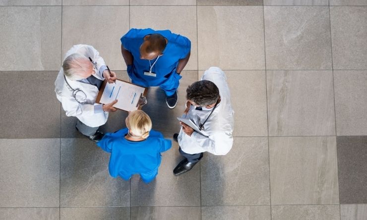 Overhead shot of group of doctors meeting in hallway having a discussion