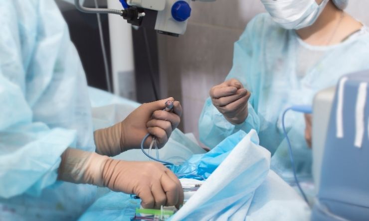 Close up of two surgeons in operating theatre preparing a patient