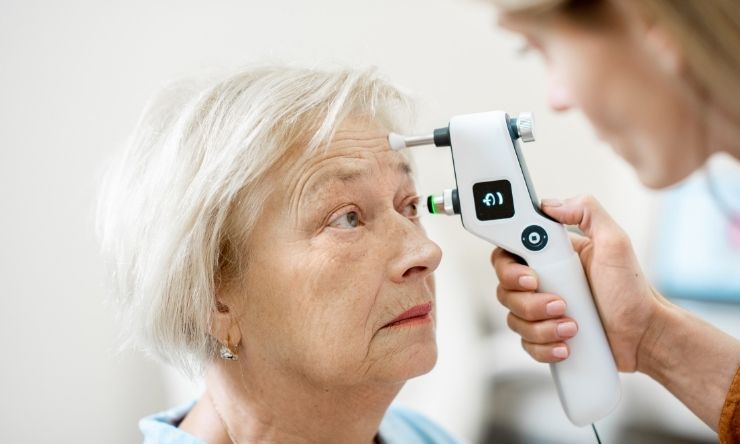 Woman having eyes inspected by eye health professional