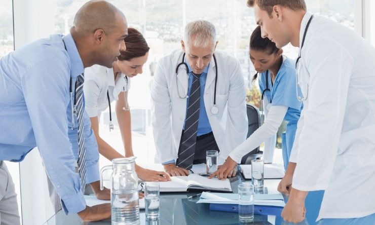 Doctors and specialists around desk conducting meeting