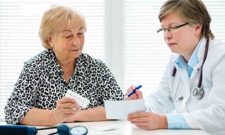 Woman sitting at desk with doctor