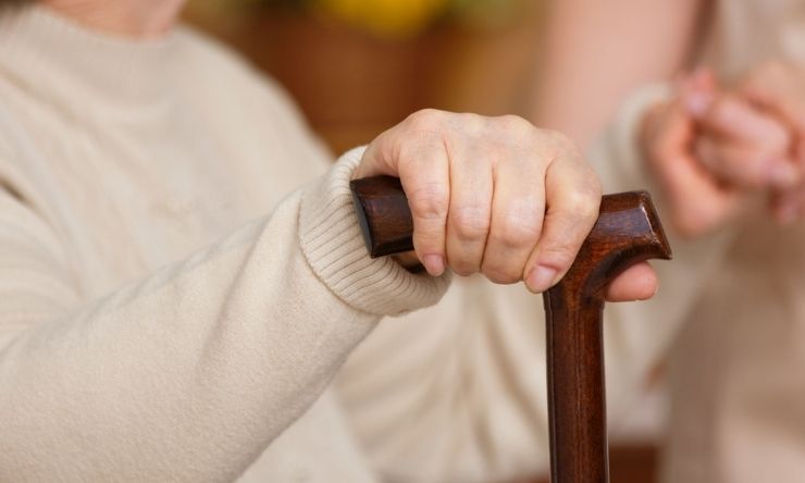 Close up of woman holding walking stick