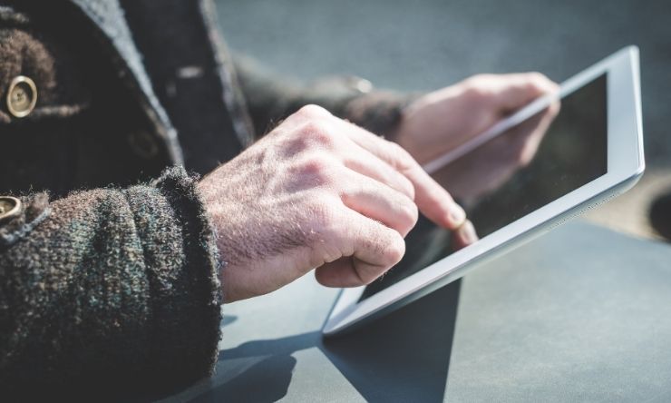 Image of elderly hands holding a smart tablet