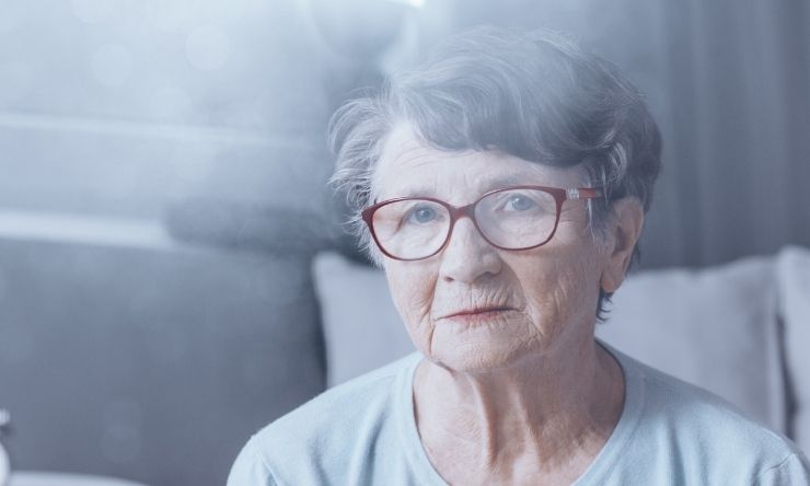 80 year old woman with grey hair and red rimmed glasses