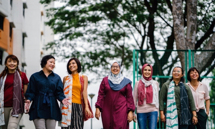 group of multi cultural women walking towards camera in urban setting