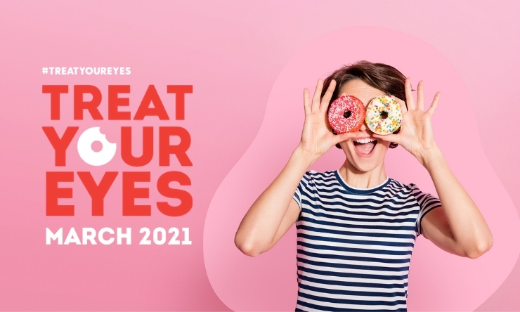 Image of woman holding iced donuts over her eyes and smiling