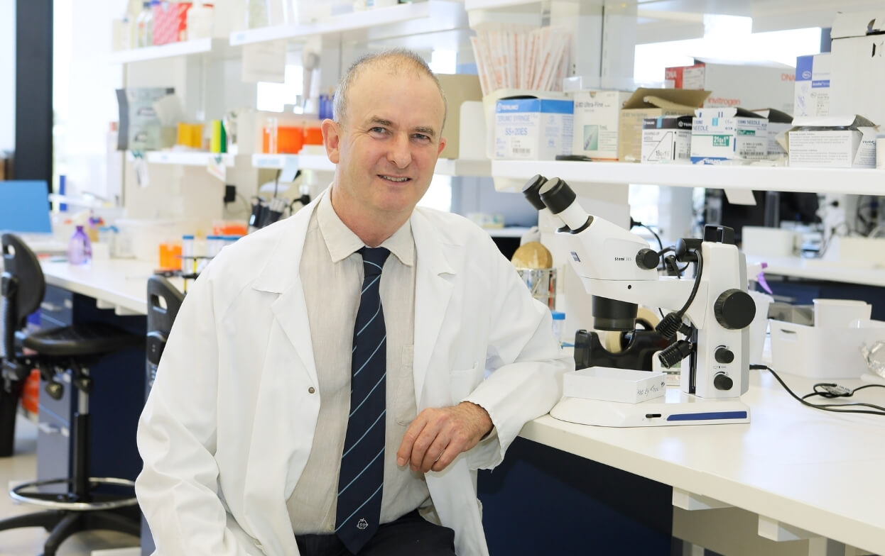 image of Professor Bill Morgan sitting in lab wearing white coat