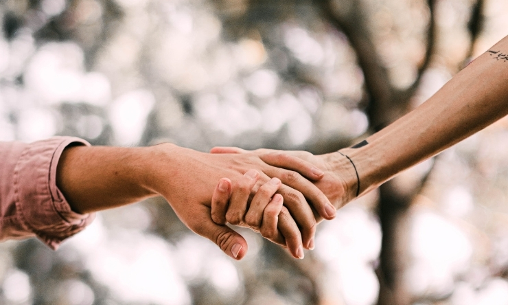 Image of two arms and hands touching in caring and united way