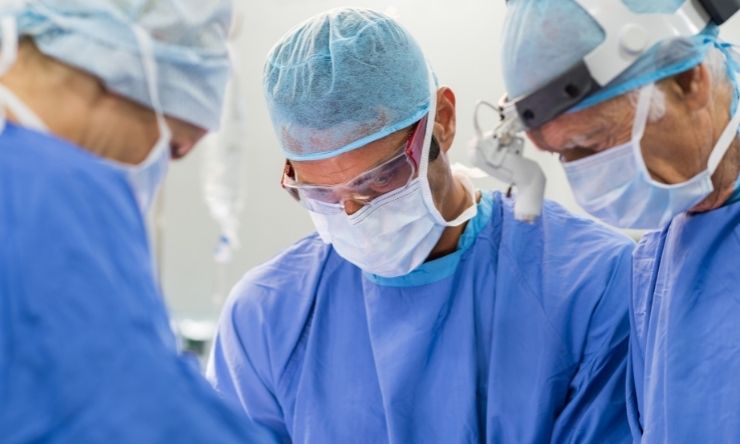 Image of three surgeons in operating theatre