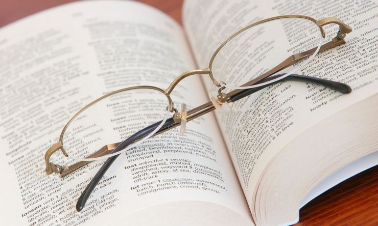 Image of folded reading glasses sitting on an open book