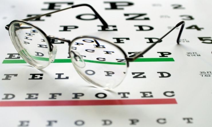 Image of reading glasses placed on a vision testing card