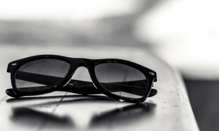 Image of dark folded sunglasses on edge of table