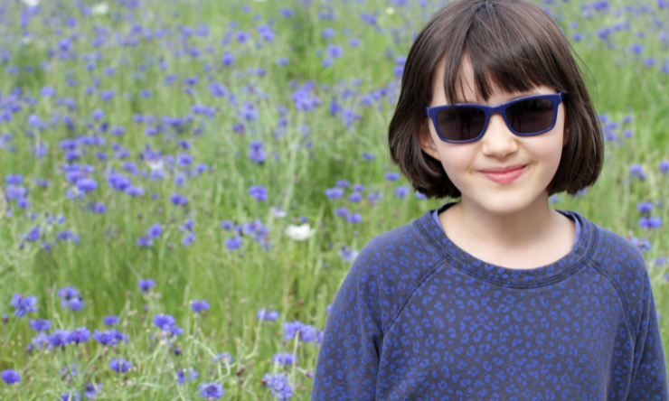 Image of a smiling child wearing sunglasses