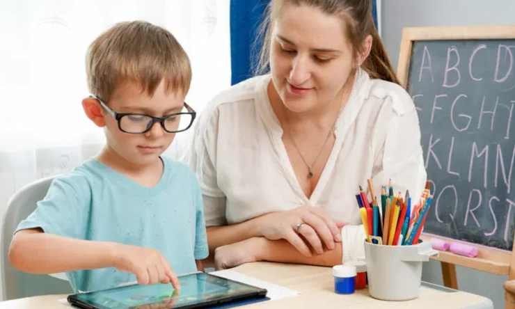 Image of a child using an ipad with their teacher
