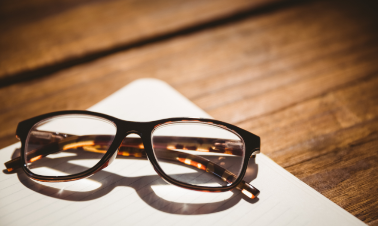 Image of a pair of reading glasses on a notepad