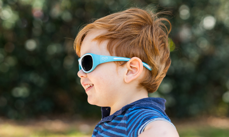 A little boy with ginger hair wearing sunglasses