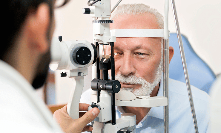 Optometrist checking an older man's eyes.