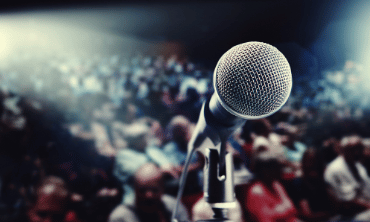 Microphone with stand looking out to a blurred audience