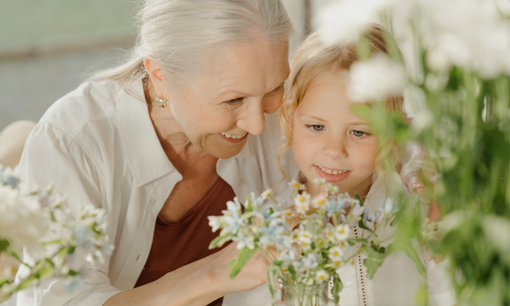 Grandmother and granddaughter arranging flowers together.