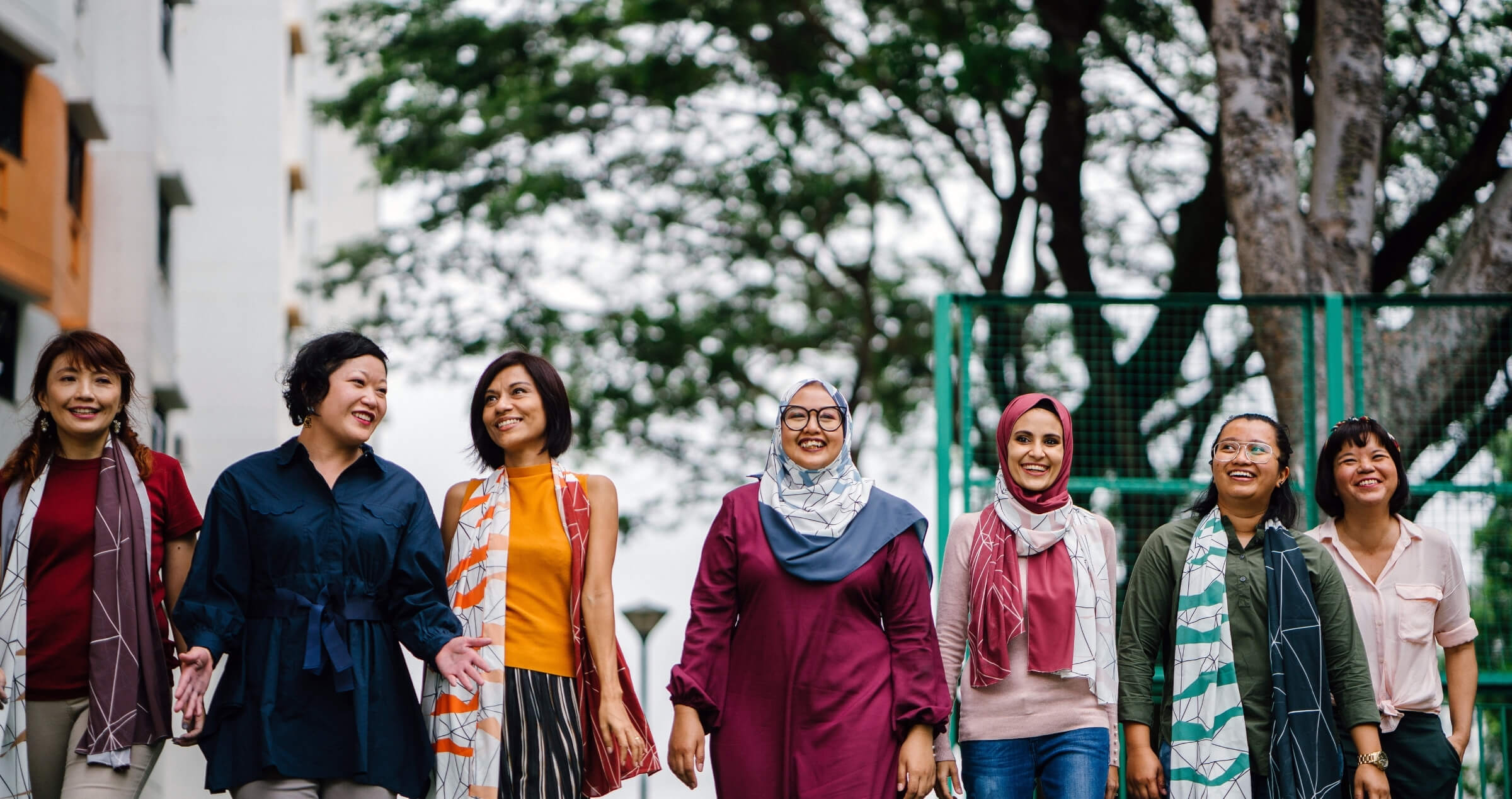 group of multi cultural women walking towards camera in urban setting