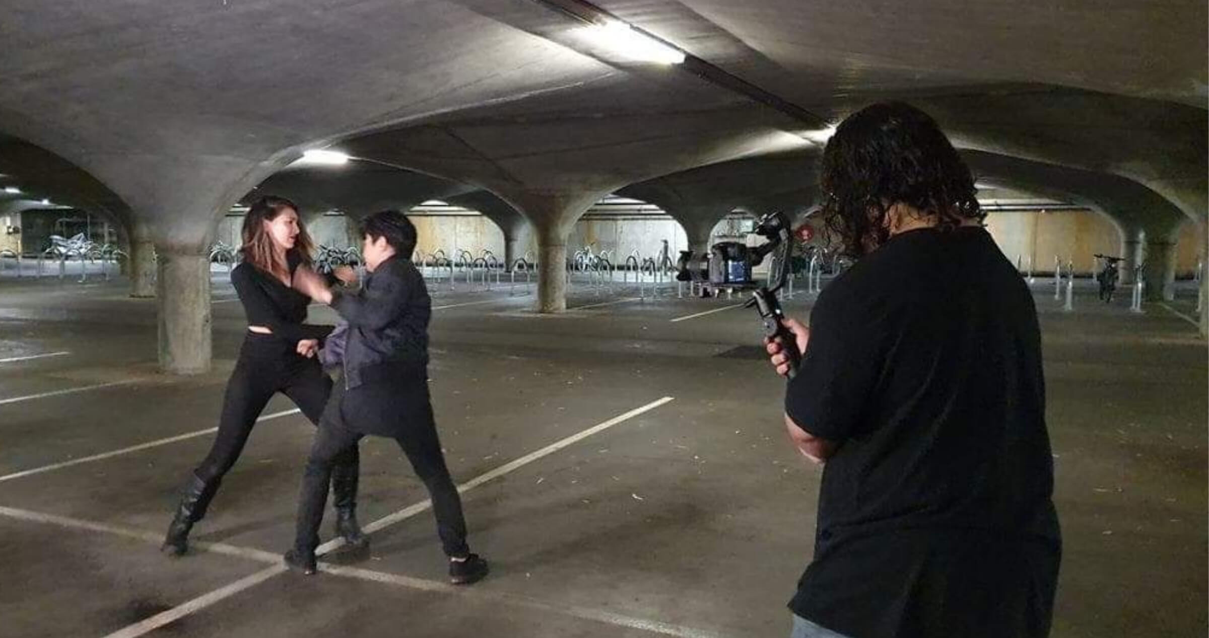 Image of young man behind camera shooting an action scene in dark underground location