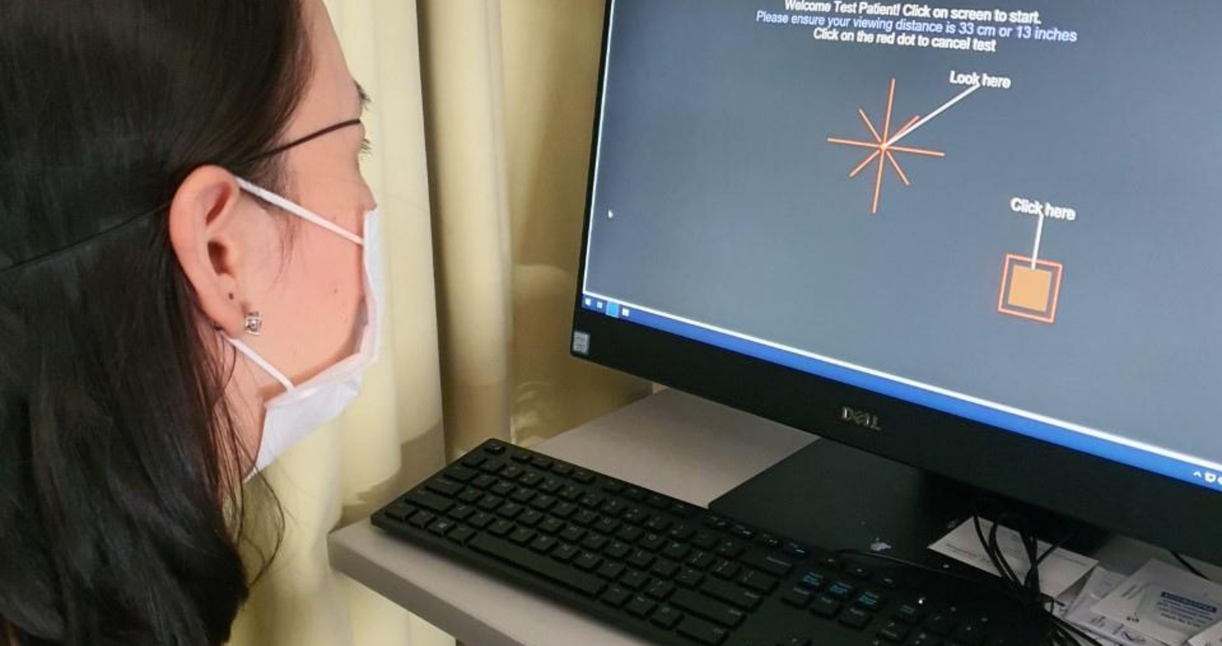 Volunteer using home computer to demonstrate visual field test software