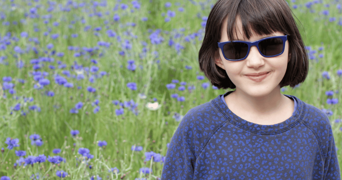 Image of a smiling child wearing sunglasses