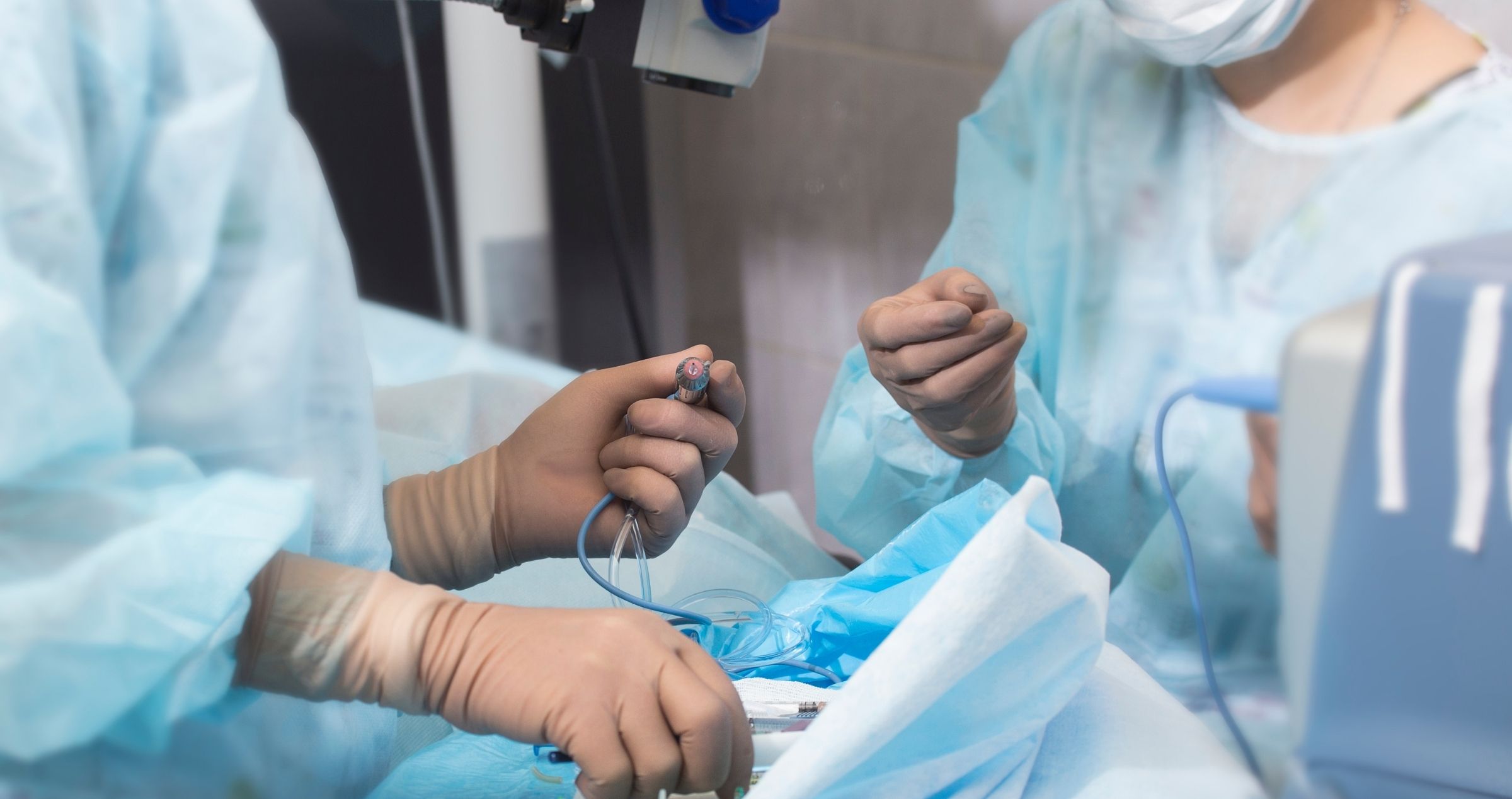 Close up of two surgeons in operating theatre preparing a patient