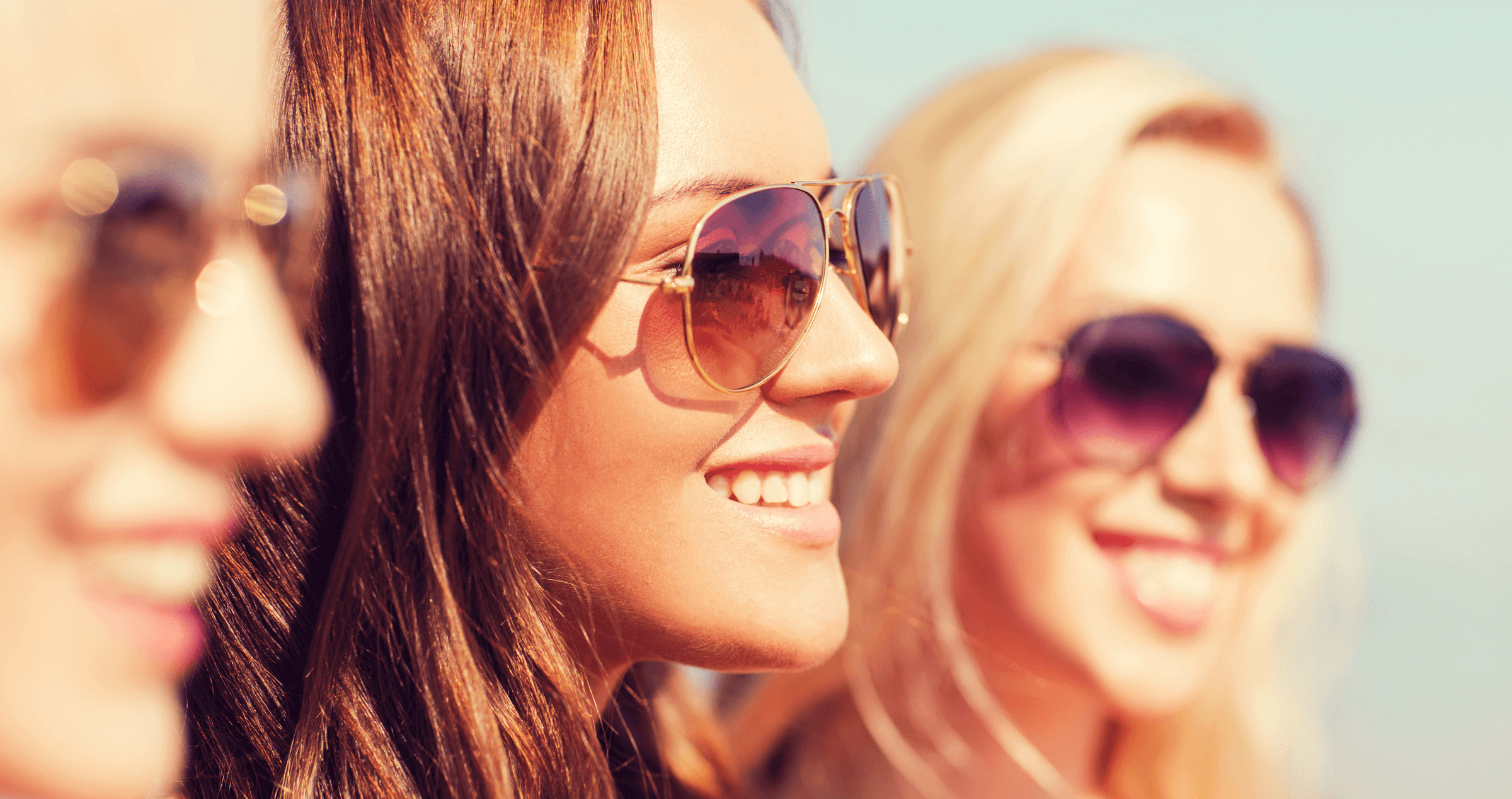 Three women wearing aviator sunglasses