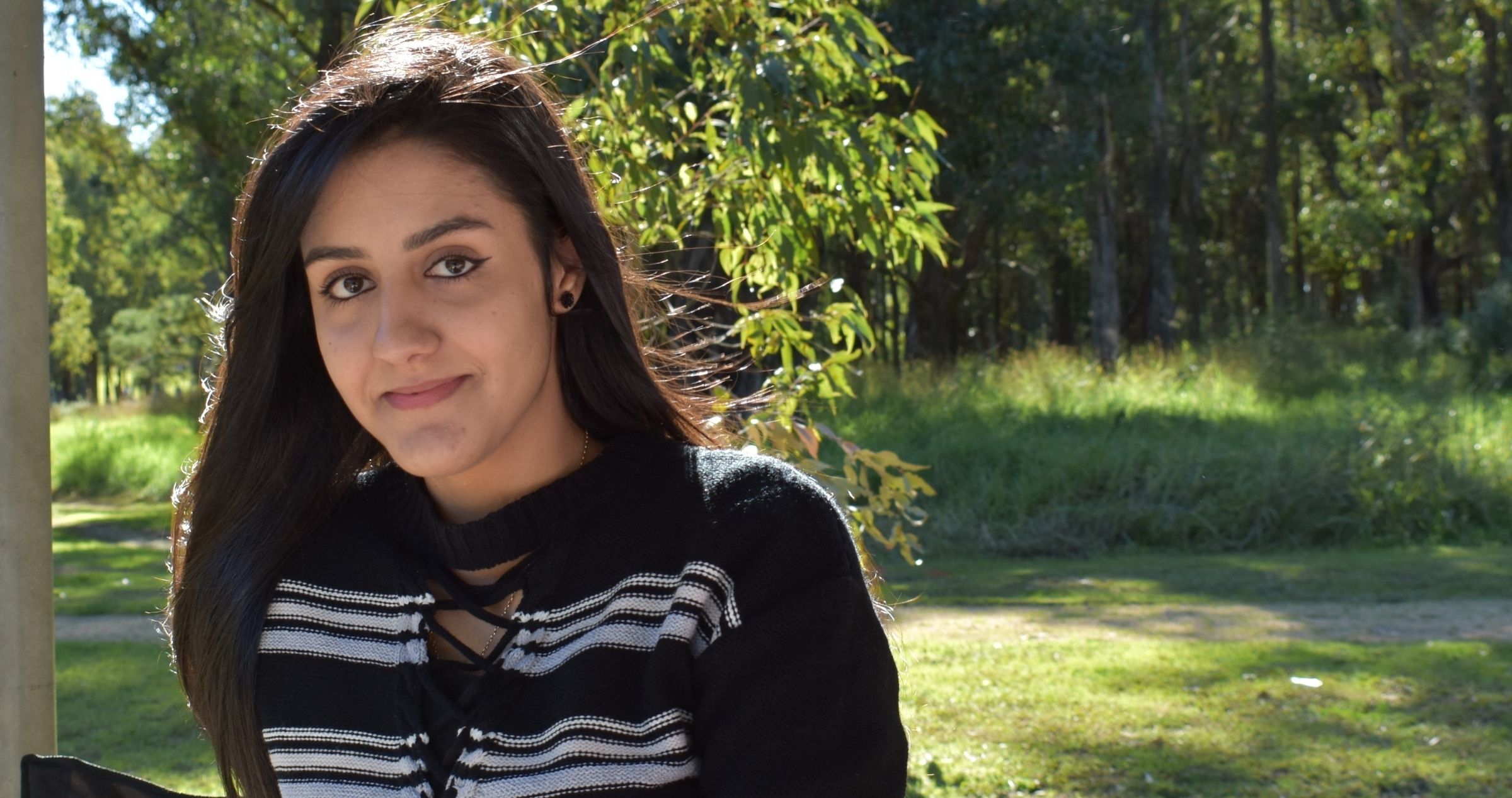 Young woman sitting in sunny and green park