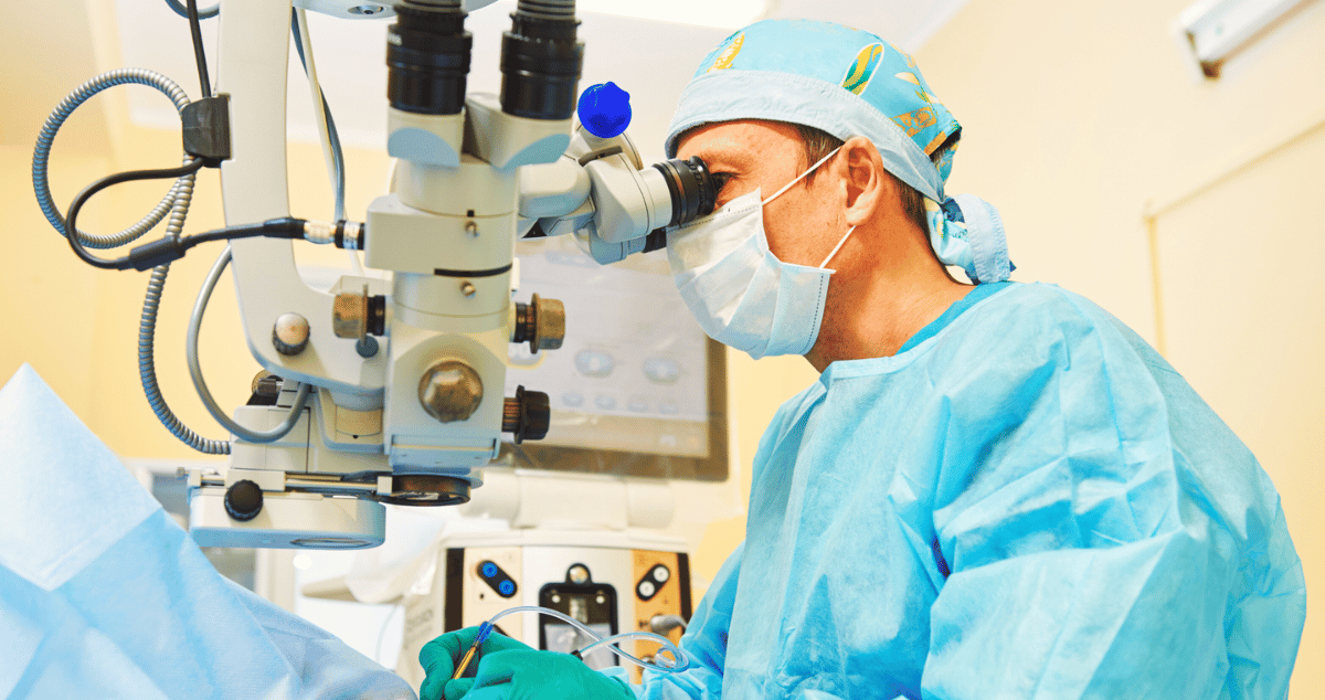 An doctor performing surgery using a microscope