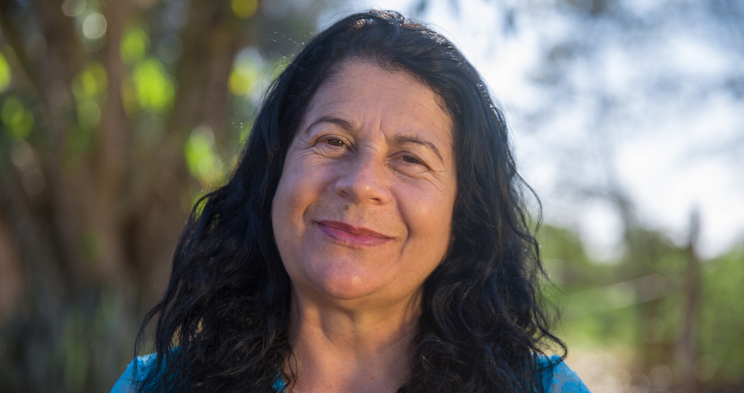 Close up image of woman with dark hair in garden