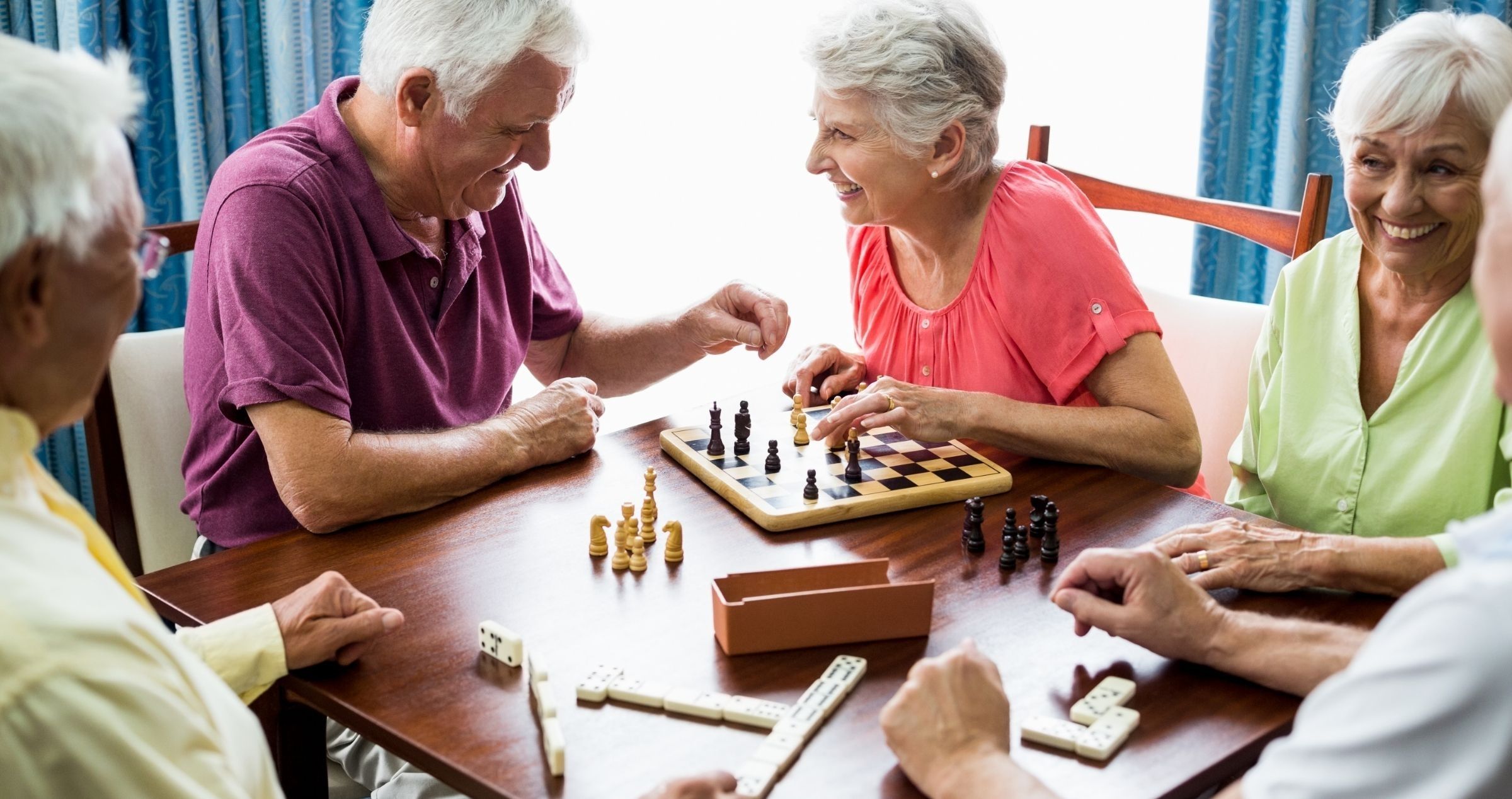 Group of retirees happily enjoying board games and conversation