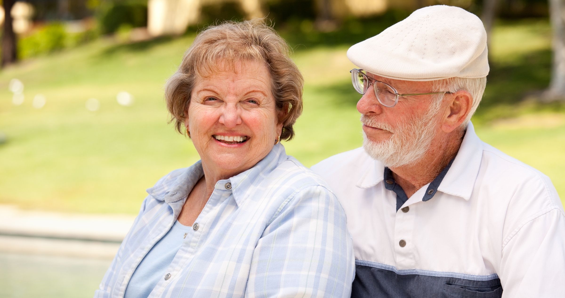 Happy older couple sitting in park