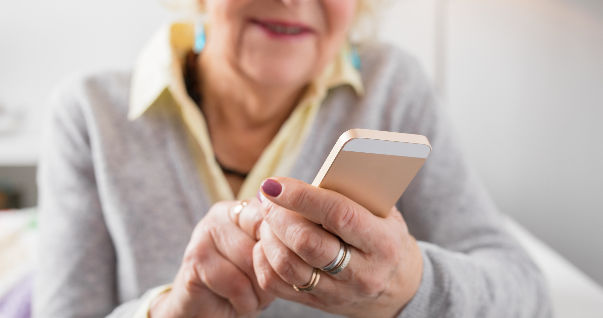 A close up of a woman's hands holding and using a mobile phone.