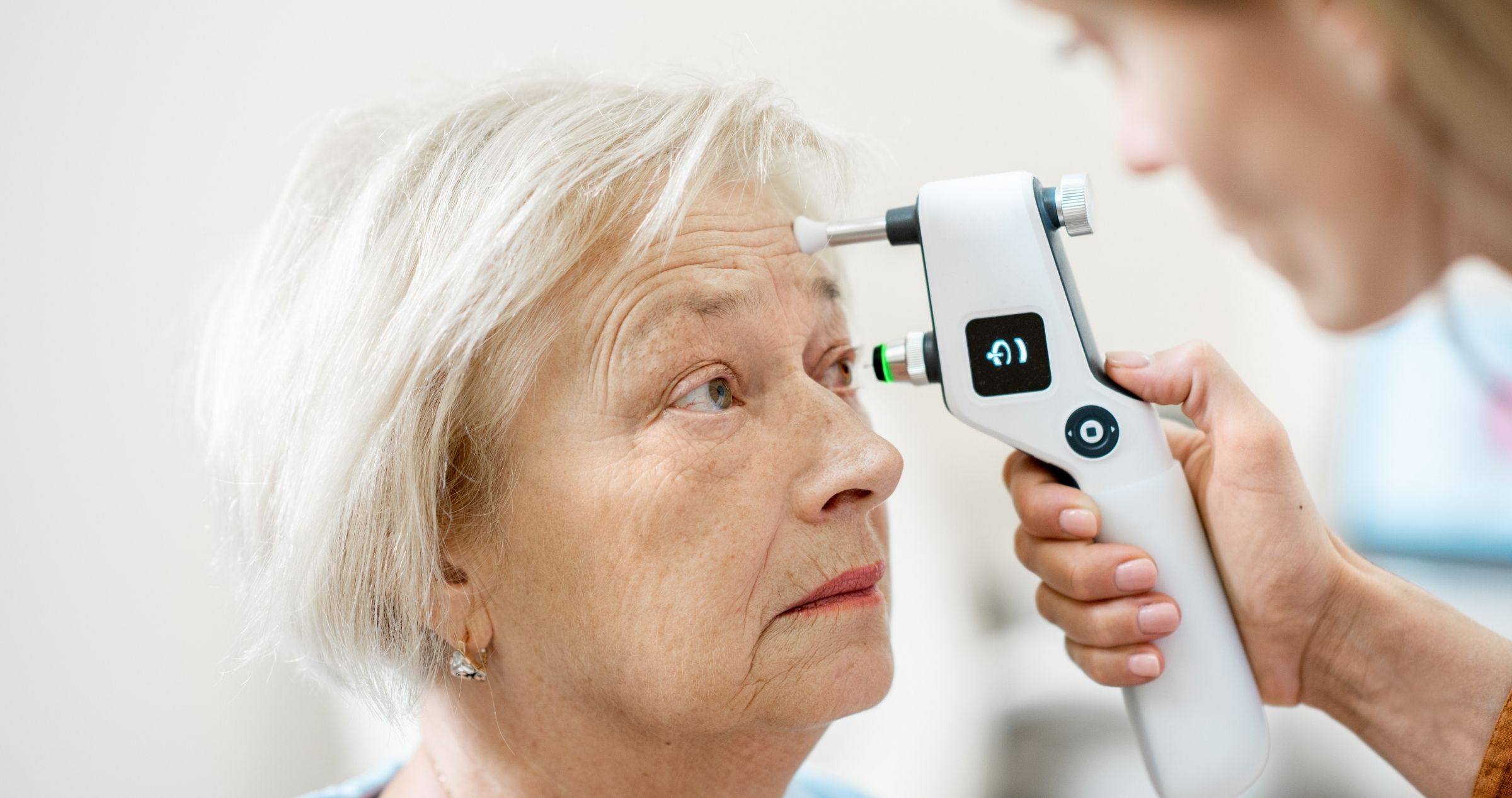 Woman having eyes inspected by eye health professional