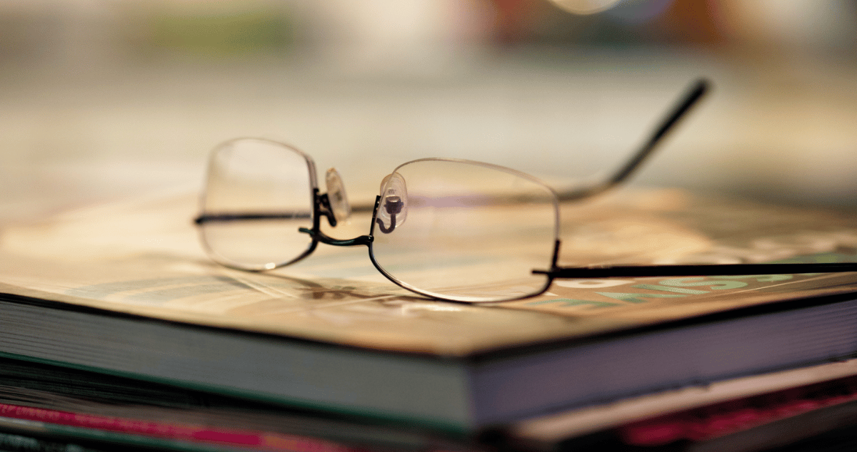 Image of reading glasses on a pile of books