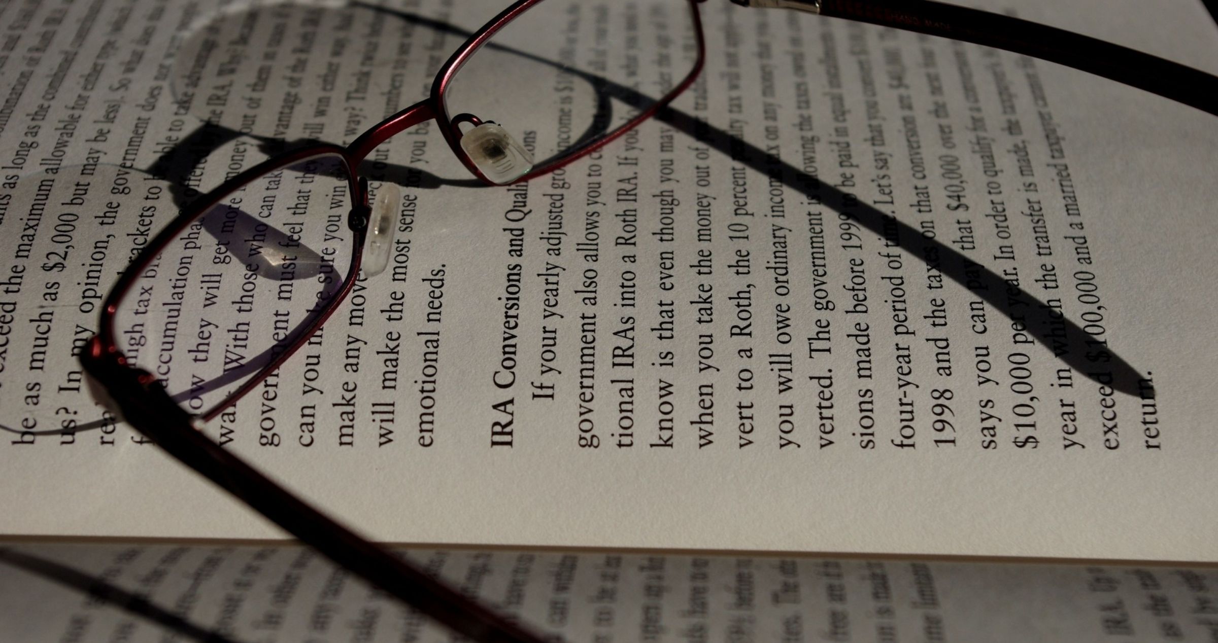 Image of reading glasses sitting on an open book