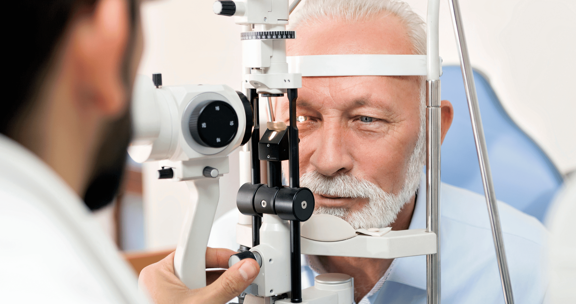 Optometrist checking an older man's eyes.