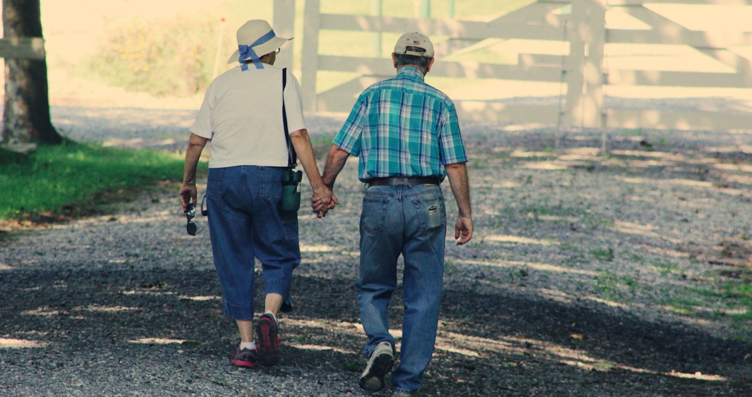 Older couple walking into farm paddock 