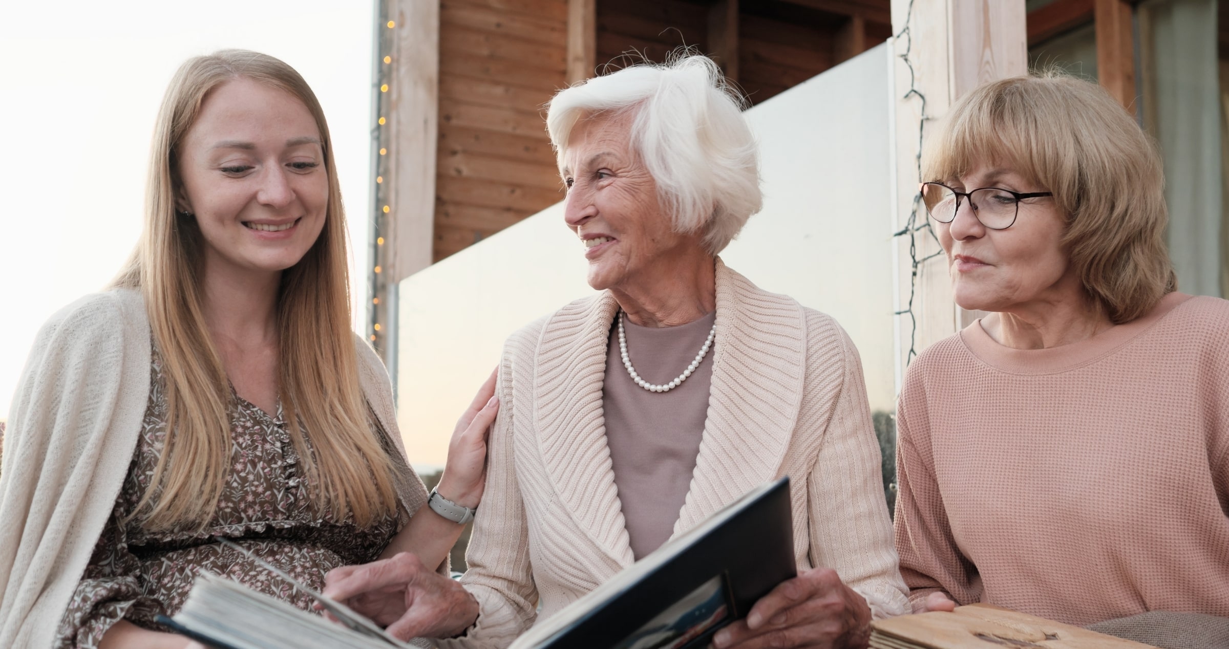 Image of a grandmother, mother, and daughter looking through family albums.