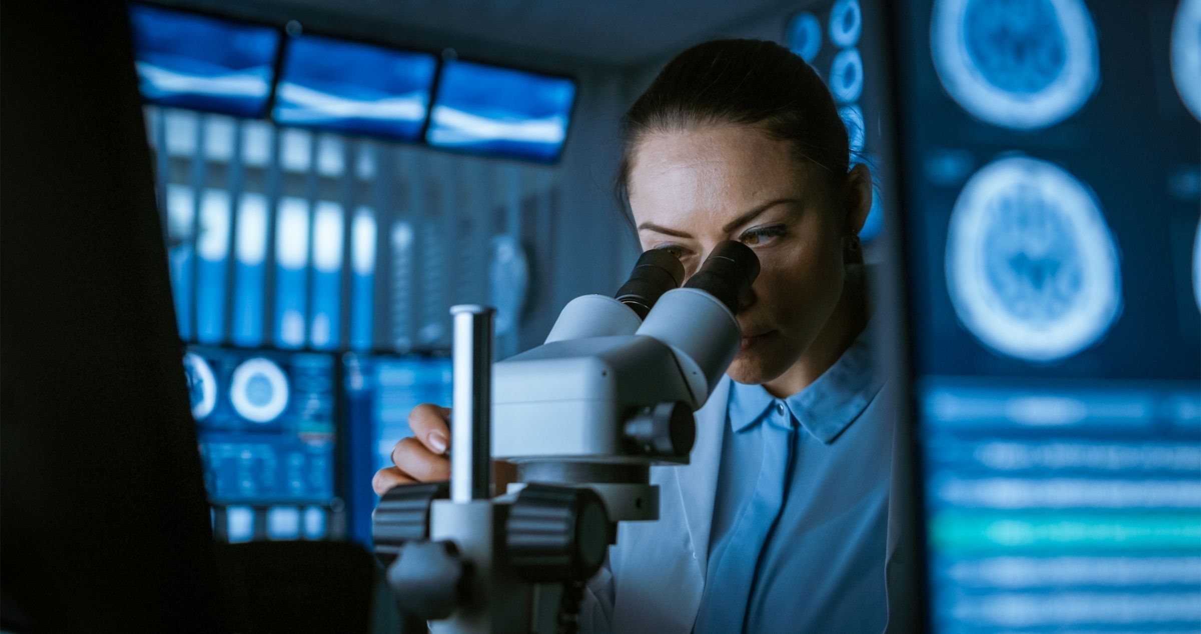 Research Technician using microscope in laboratory