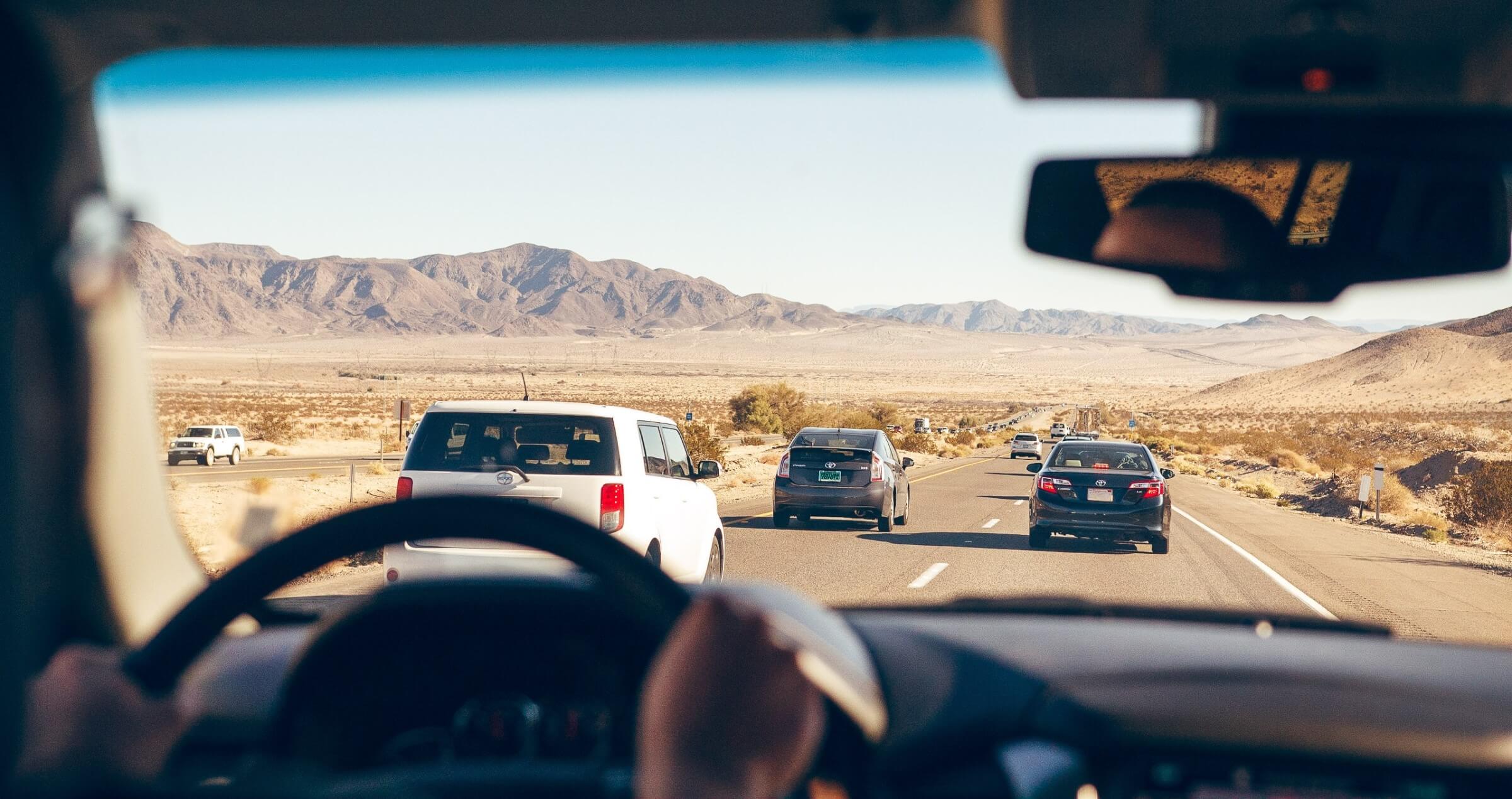 Looking forward out a car windscreen at busy lanes of traffic ahead