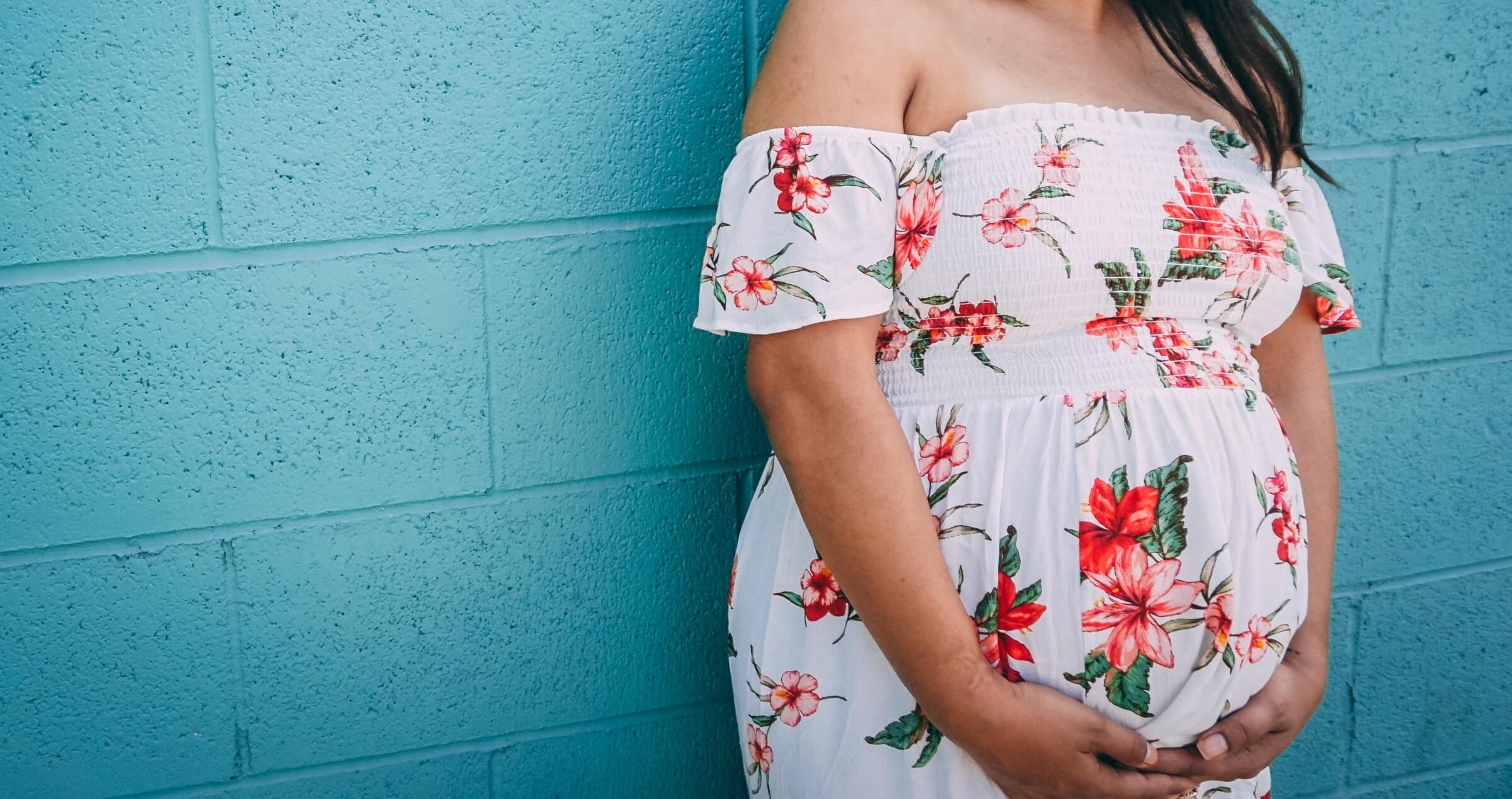 Young Hispanic woman holding her pregnant stomach