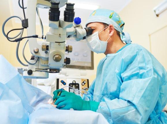 Male ophthalmologist in an operating theater conducting eye surgery