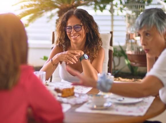 A group of woman having coffee together on a sunny terrace